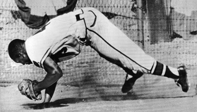 Wes Covington hung onto the ball after his leaping catch in left field near the 355-foot sign nabbed a long blow from Gil McDougald in the fourth inning of Game Five. (DAVID KLUG COLLECTION)