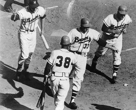 Lou Burdette (33) was congratulated by Billy Bruton (38) after hitting a three-run home run to extend the Braves’ early 7–1 first-inning lead in Game Two. (ROBERT KOEHLER COLLECTION)