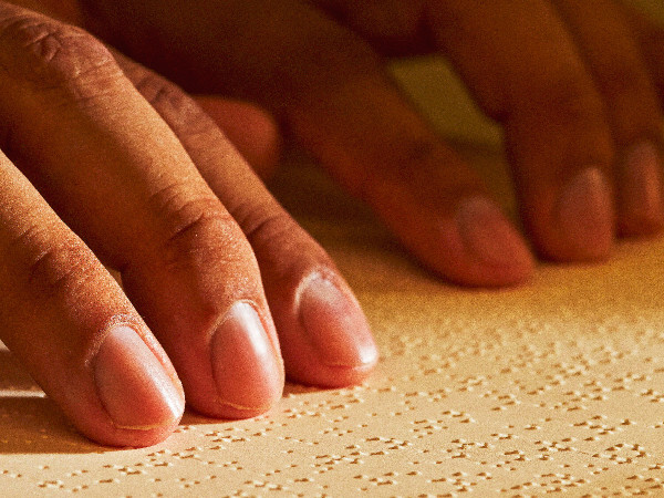 A person reads a Braille Watchtower magazine