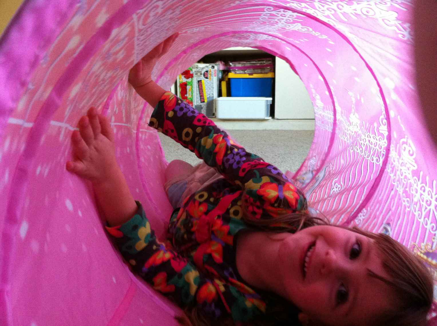 a child rolling around in a pink tube