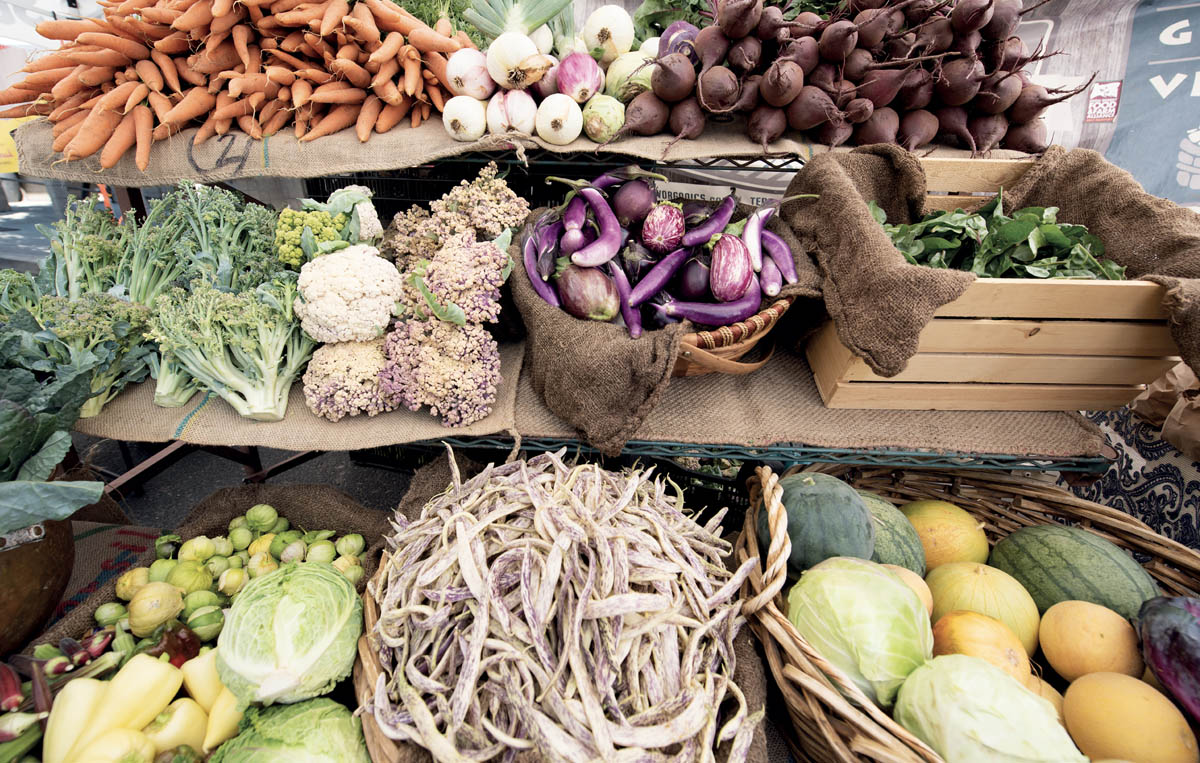 A stand with lots of vegetables at a farmers market