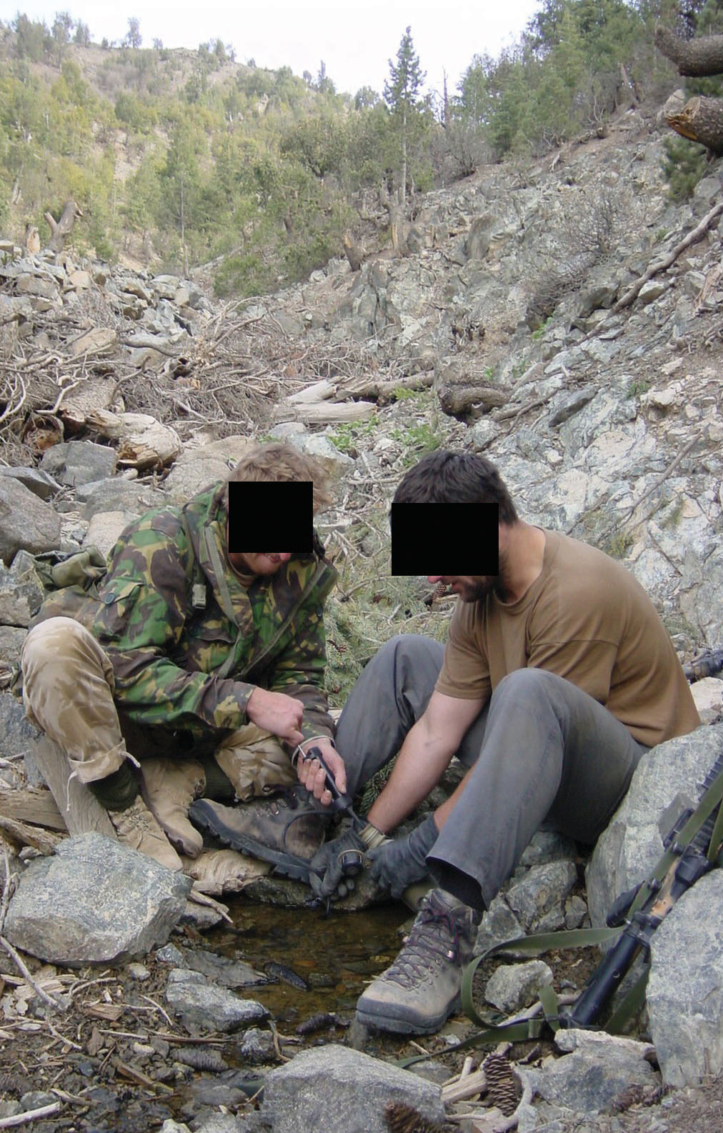 Using a Katadyn filter dehydrated SBS soldiers extract life-saving water from a seepage at the foot of the mountain.