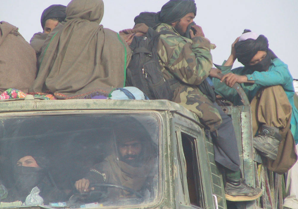 Hiding their faces with their turbans, the foreign Taliban prisoners arrive at Qala-I-Janghi fortress by the truck-load.