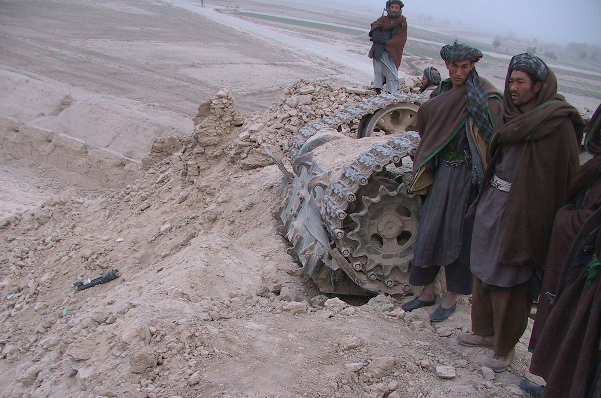 Northern Alliance soldiers survey the scene of devastation where a US airstrike hit friendly forces, blowing up a T55 tank and its crew and killing and wounding dozens of SBS, US and Afghan fighters.