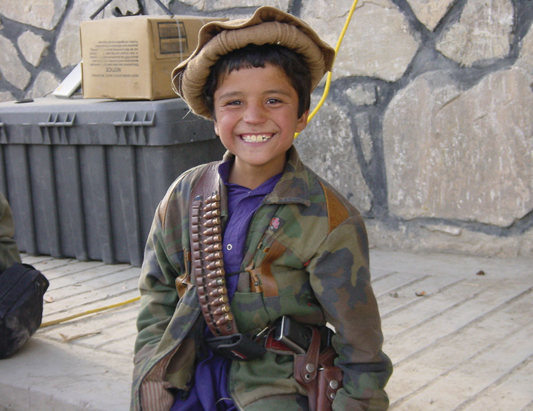 BoySoldier-NA: Northern Alliance forces fighting the Taliban and Al Qaeda included boy soldiers like this one, proudly sporting his pistol and ammo belt.