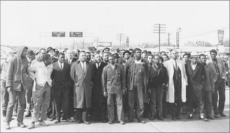 Selma, March halted at the bridge, March 9, 1965 (Stokely Carmichael, far left ; MLK, Jr. fifth from left ). The Jack Rabin Collection on Alabama Civil Rights and Southern Activists, Box 4, Items 050. Courtesy of Historical Collections and Labor Archives, Special Collections Library, The Pennsylvania State University.