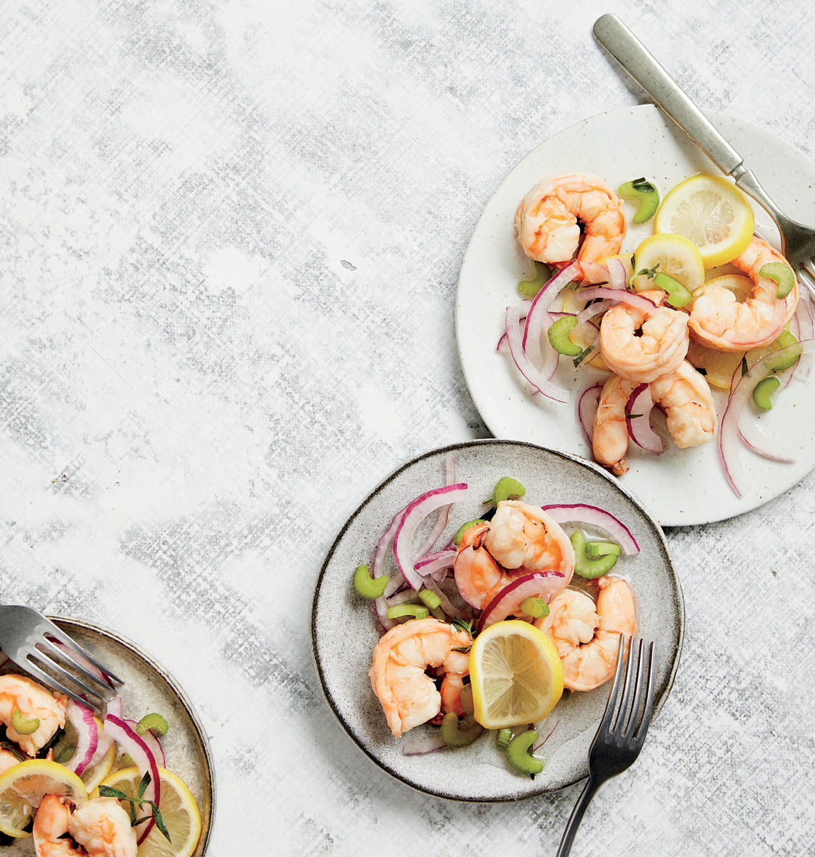 A few small plates of pickled shrimp and vegetables.