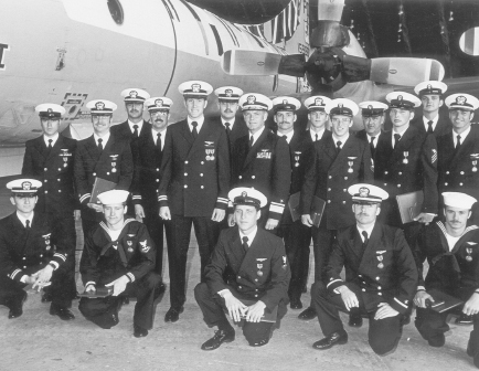 On 30 April 1979, Rear Adm. Charles Prindle presented medals to Crews 6 and 11, the survivors of AF 586, and the crew of XF 675, in Patrol Squadron 9’s hangar at Moffett Field. XF 675 was the first U.S. Navy aircraft on scene. Crew 11 was standing the one-hour alert at Adak when AF 586 went down. Standing, left to right: PO 1st Class Len Northrop (FE), Lt. Pat Conway (tacco), Lt. (jg) Denny Mette (nav/comm), Lt. (jg) Matt Gibbons, Lt. Ed Caylor, Lt. (jg) Randy Luecker (2P), Rear Admiral Prindle, PO 3d Class Pete Geldard (Sensor 1), Lt. (jg) Van Gamble (3P), PO 3d Class John Hample (Sensor 3), PO 1st Class Hugh Littlejohn (IFT), Airman Bill Ratteni (Sensor 2), PO 2d Class Ed Flow, and Lt. (jg) John Ball. Kneeling, left to right: Lt. (jg) Bruce Forshay, PO 3d Class Gene Cummings (Ord.), PO 3d Class Howard Moore, Ens. John Wagner, and Airman Dave Reynolds. (XF 675’s plane commander, Lt. Ron Price, not pictured. XF 675 crew positions in parentheses.) U.S. NAVY