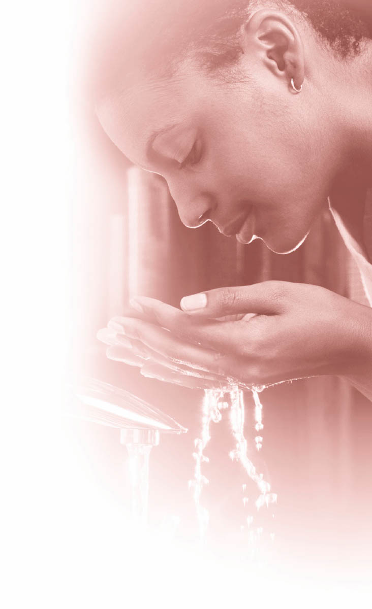 A woman washing her face with a handful of water.