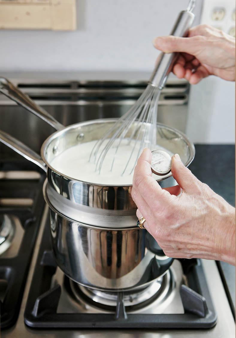 Taking the temperature of a saucepan of milk on the stove