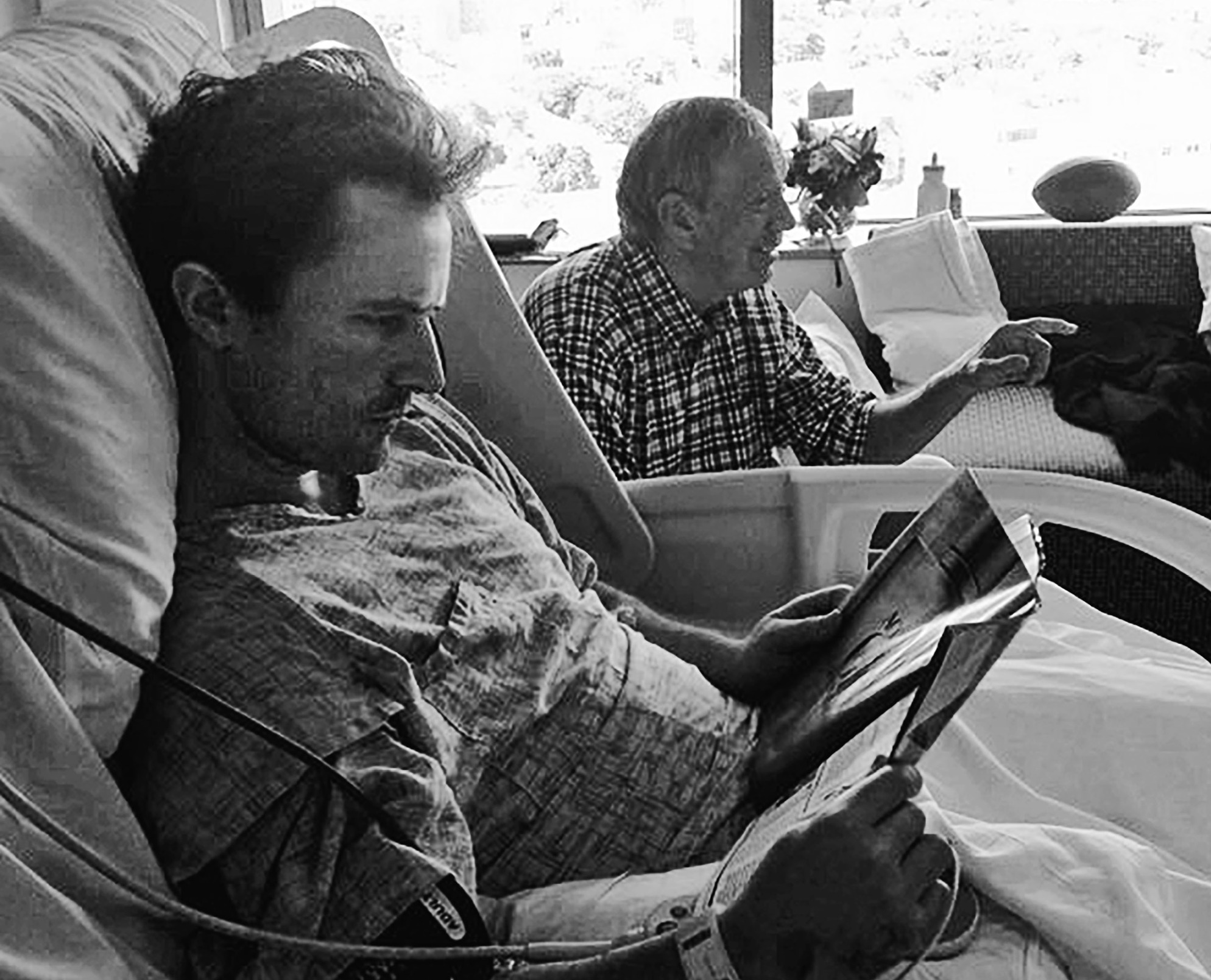 The early days in the ICU. Dave is disoriented and sleeps much of the time, surrounded by family and doctors. Here, he tries to read.