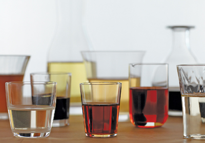 Variously sized glasses with variously colored alcohols in them