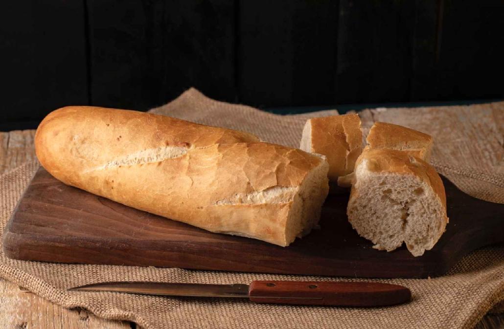 A sandwich sitting on top of a wooden cutting board  Description automatically generated