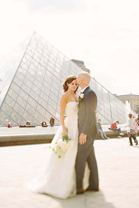 Photo of couple in front of Louvre.