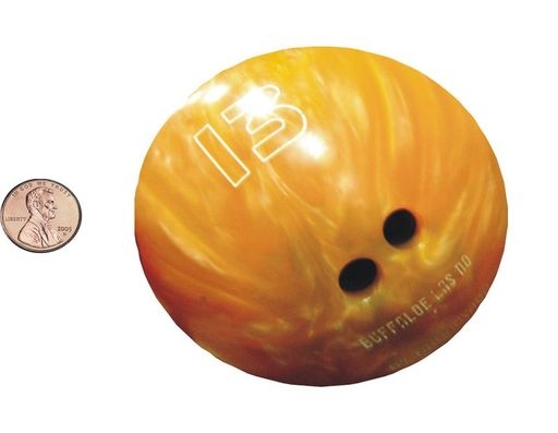 Composite image of bowling ball and penny