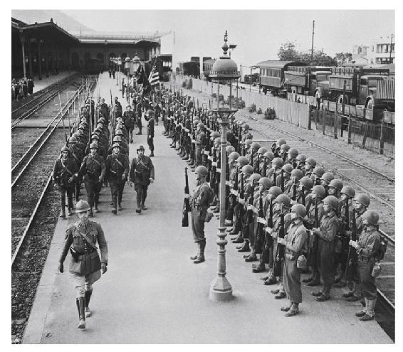 Illustration. Un détachement de GI’s (soldats américains) salue le départ de soldats français pour la Tunisie. Gare d’Oran, décembre 1942. 14. Un détachement de GI’s en gare d’Oran, décembre 1942 (© Bettmann/Getty Images).