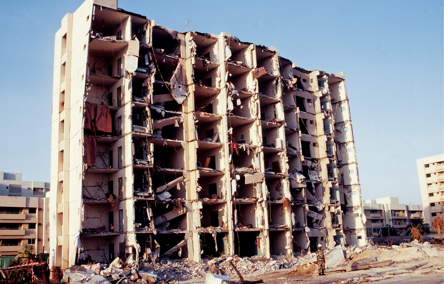 An overall view of the north side of the building that was severely bomb damaged in the Khobar Towers complex.  The explosion of a fuel truck set off by terrorists at 2:55 p.m. EDT, Tuesday, June 25, 1996, outside the northern fence of the Khobar Towers complex near King Abdul Aziz Air Base, killed 19 and injured over 260.  The facility housed U.S. service members and served as the headquarters for the 4404th Wing (Provisional), Southwest Asia.