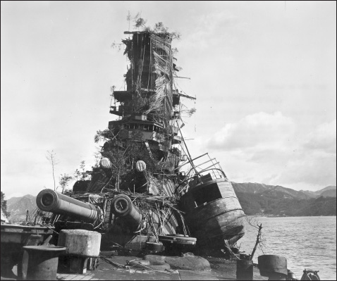 PHOTO 5.4. The face of defeat. The Japanese battleship Haruna wrecked in Kure Harbor immediately postwar, festooned with ineffective camouflage. (U.S. Naval Institute Photo Archives)