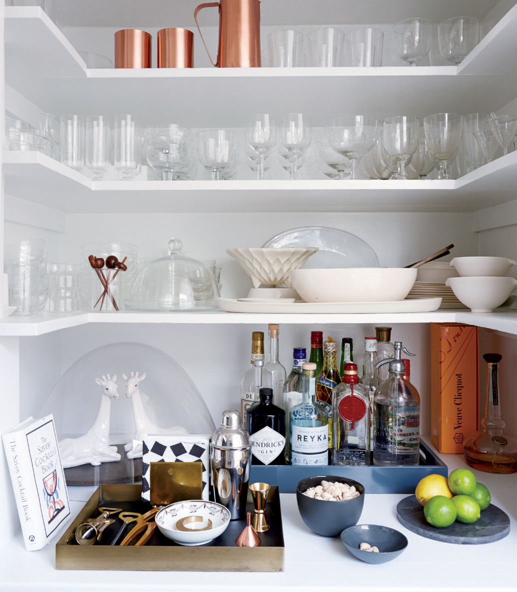 Trays help separate tools, liquor, and fruit so guests can find exactly what they need and corral all the tools. A cocktail book gives them courage to try that new artisanal manhattan all the kids are raving about.