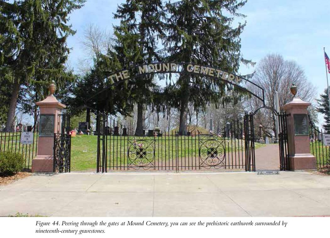 Figure 44. Peering through the gates at Mound Cemetery, you can see the prehistoric earthwork surrounded by nineteenth-century gravestones.