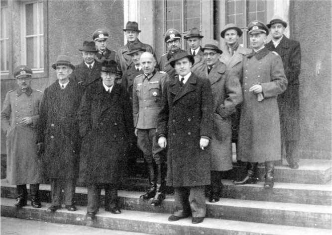  Hugo Eckener (third from left, on bottom step) and his son, Knut (in dark hat, tallest man in back row), attended a 1942 meeting at the super-secret V2 rocket installation at Peenemünde, Germany. At far right in the front row is Wernher von Braun, later an architect of America’s space program. Only trusted people could set foot on the Nazi base. © ARCHIV DER LUFTSCHIFFBAU ZEPPELIN GMBH, FRIEDRICHSHAFEN