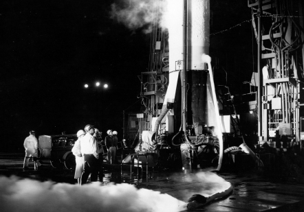 Seemingly nonchalant pad workers inspect a fueled Redstone-Mercury vehicle in the predawn hours at Cape Canaveral before the ...