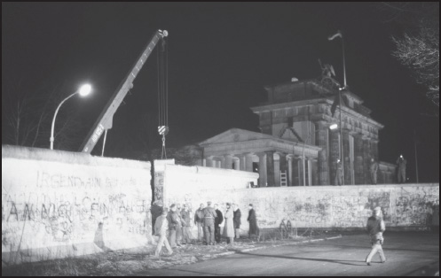 East and West Germans converse at the newly created opening in the Berlin Wall after a crane removed a section of the structure beside the Brandenburg Gate, December 21, 1989. 