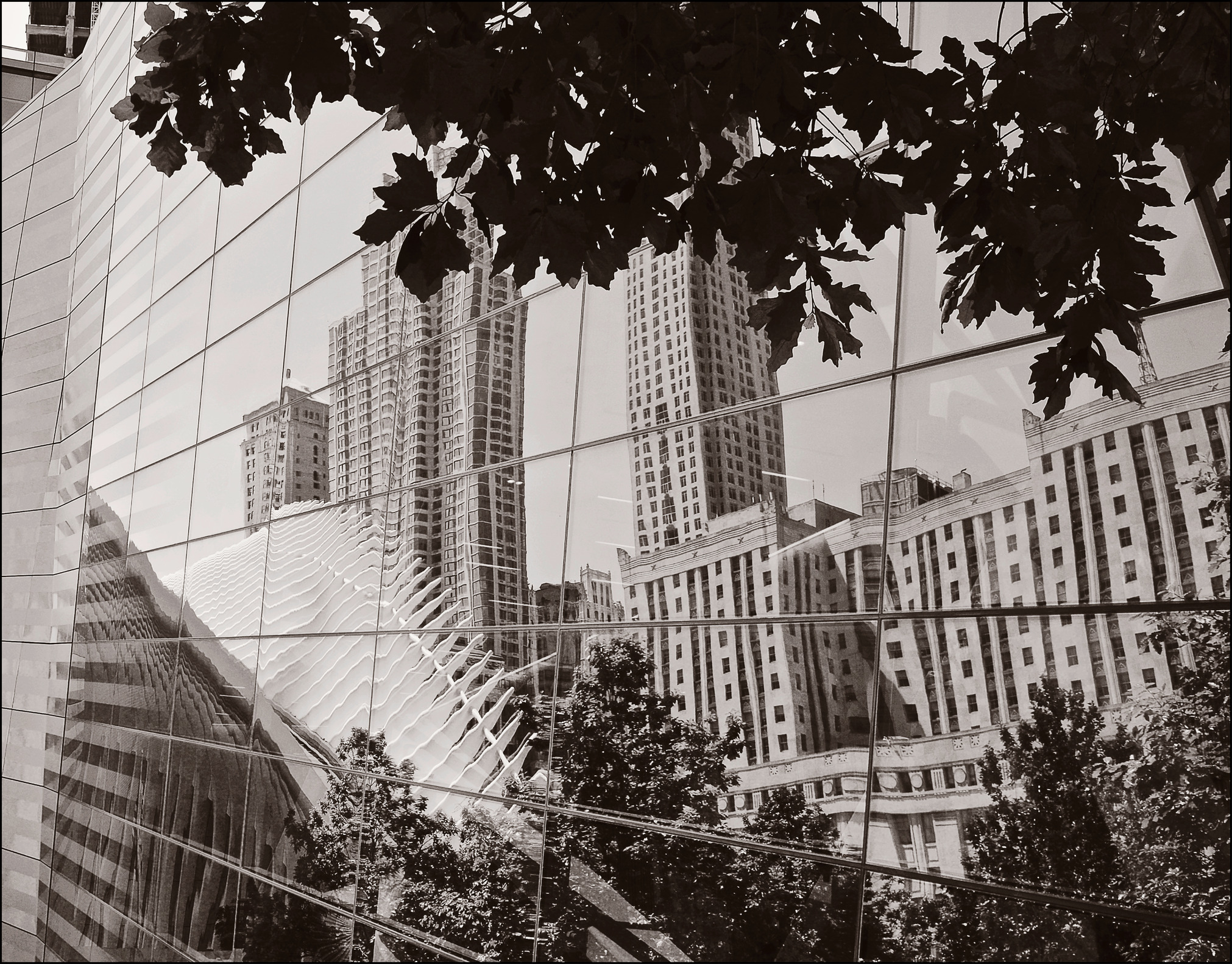 9/11 Memorial Museum pavilion, with the transit hub and plaza reflected in the façade