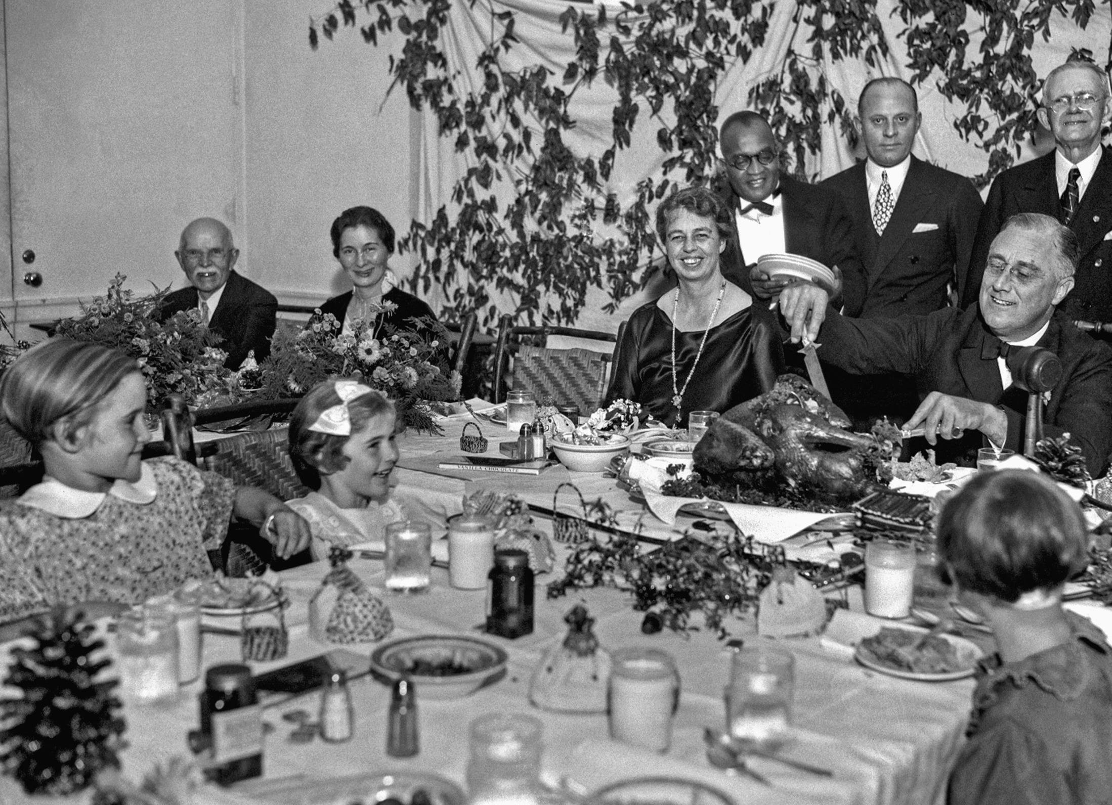 President Franklin D. Roosevelt carves the turkey during the annual Thanksgiving dinner for polio patients at Warm Springs, Ga., with first lady Eleanor Roosevelt smiling beside him, Dec. 1, 1933.  (AP Photo)