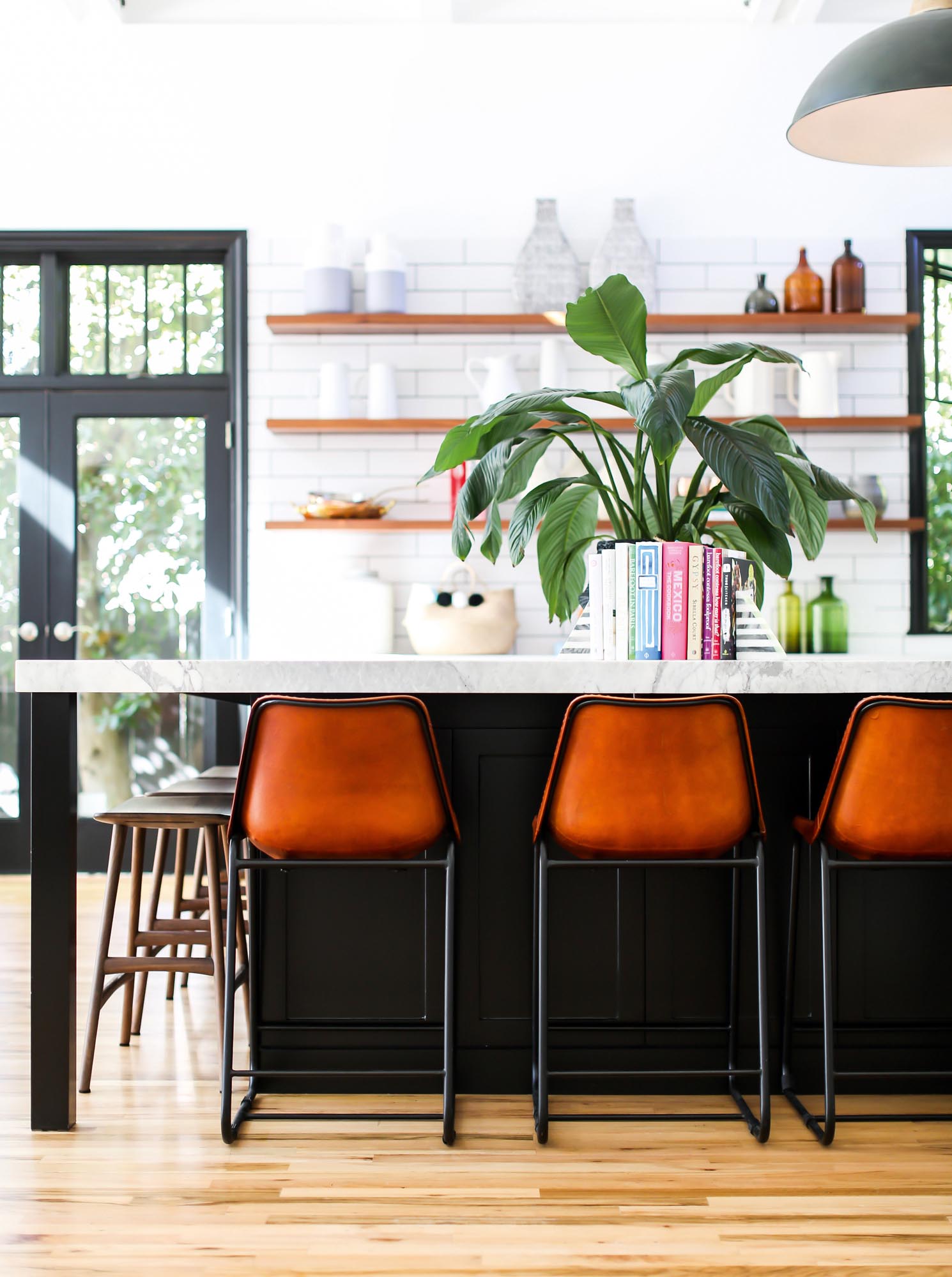 Contemporary steel stools juxtaposed with traditional wood stools surround the open kitchen on the main floor.