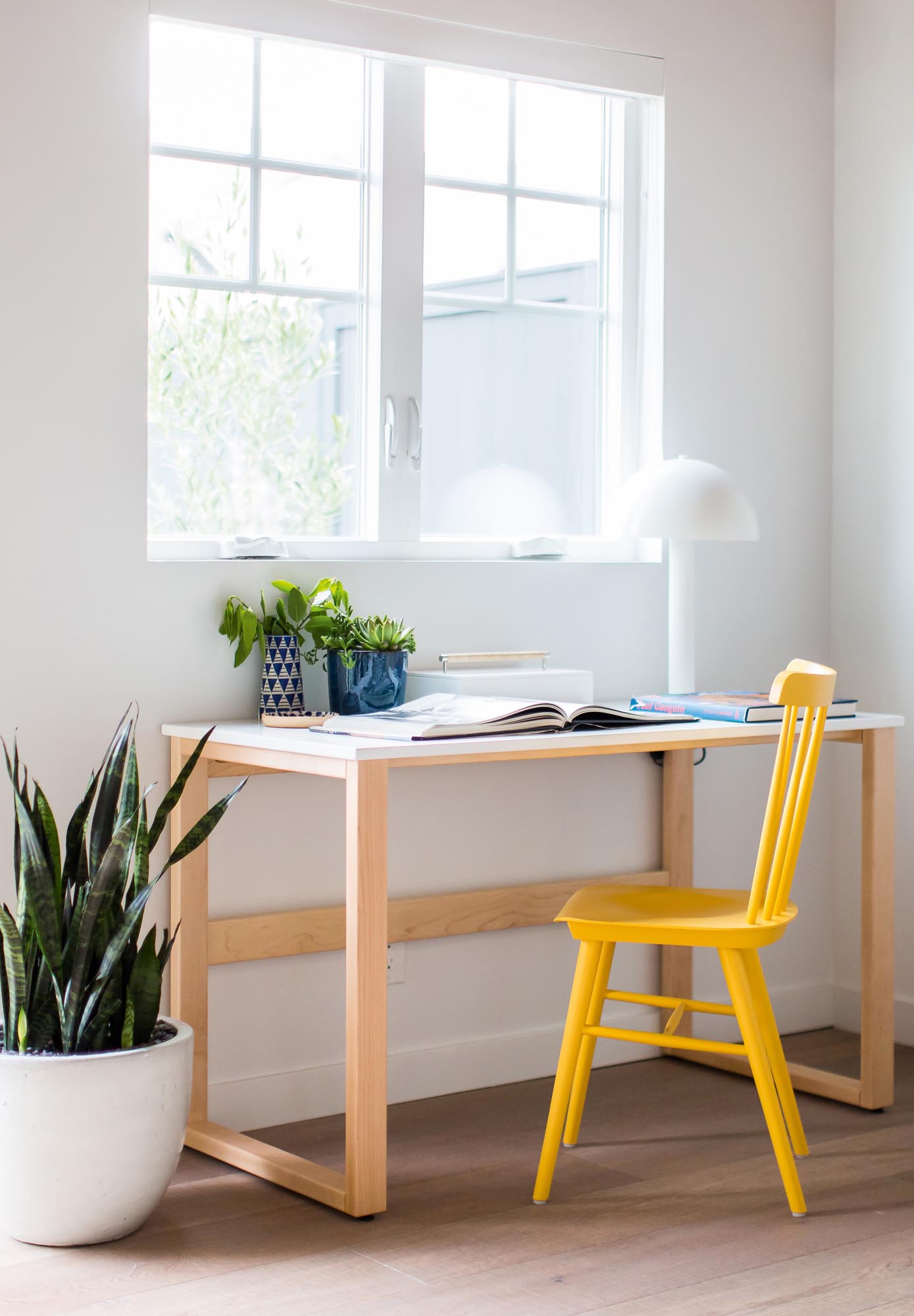 Photo of a minimal desk with a bright yellow chair.