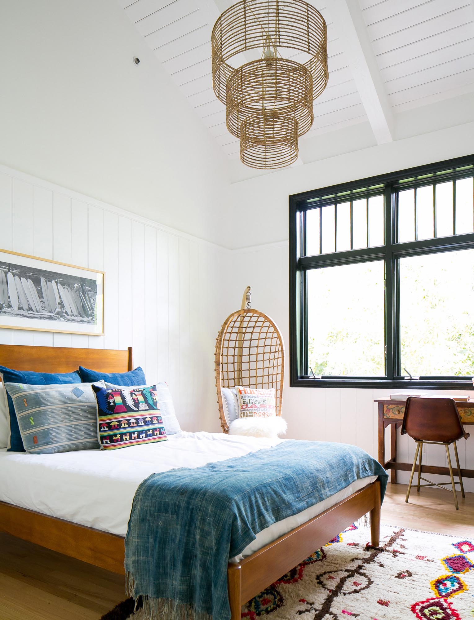 Photo of a bedroom with colorful rug and pillows.