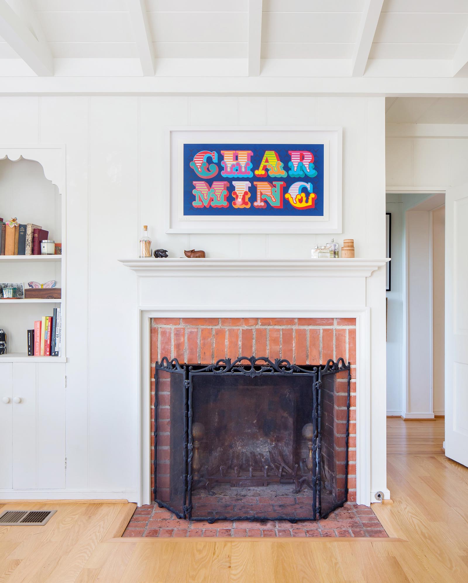 Photo of fireplace with bold colored art above.