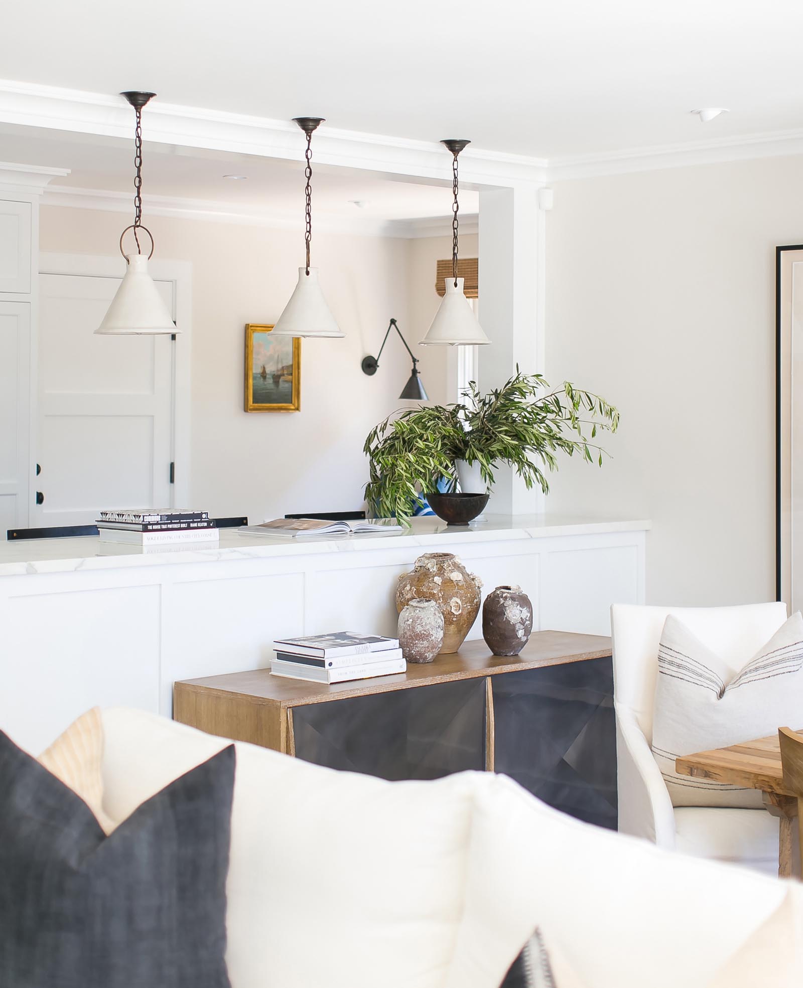 Custom pendant lighting hangs above an informal dining area that looks through to the formal dining room.