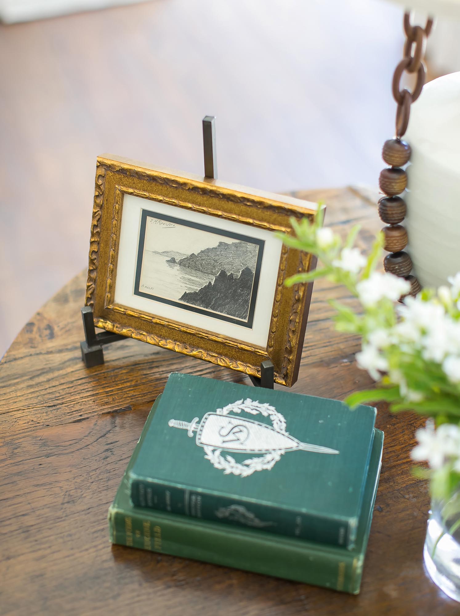 Close-up photo of the books and art on the side table.