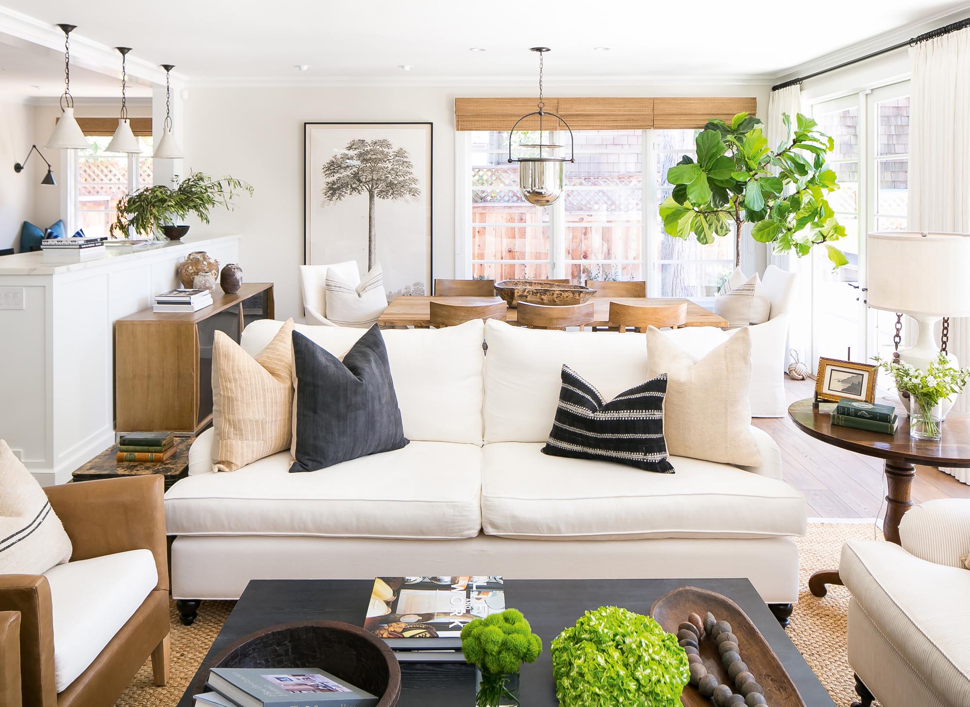 Photo of living area with cream sofa and chair with natural wood tables.