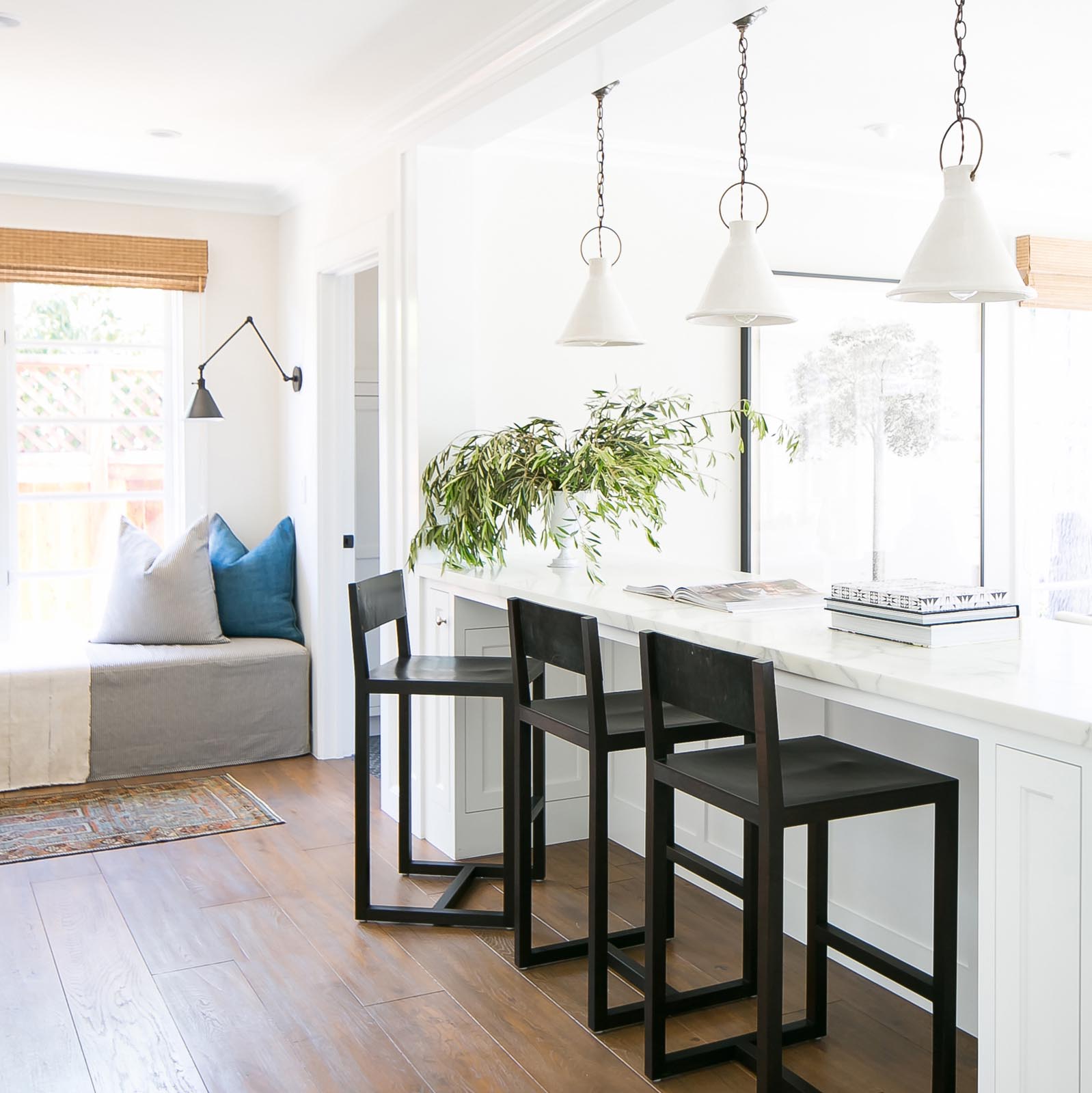 The contemporary wood stools are designed to offer a bold complement to the Benjamin Moore “China White” interior.