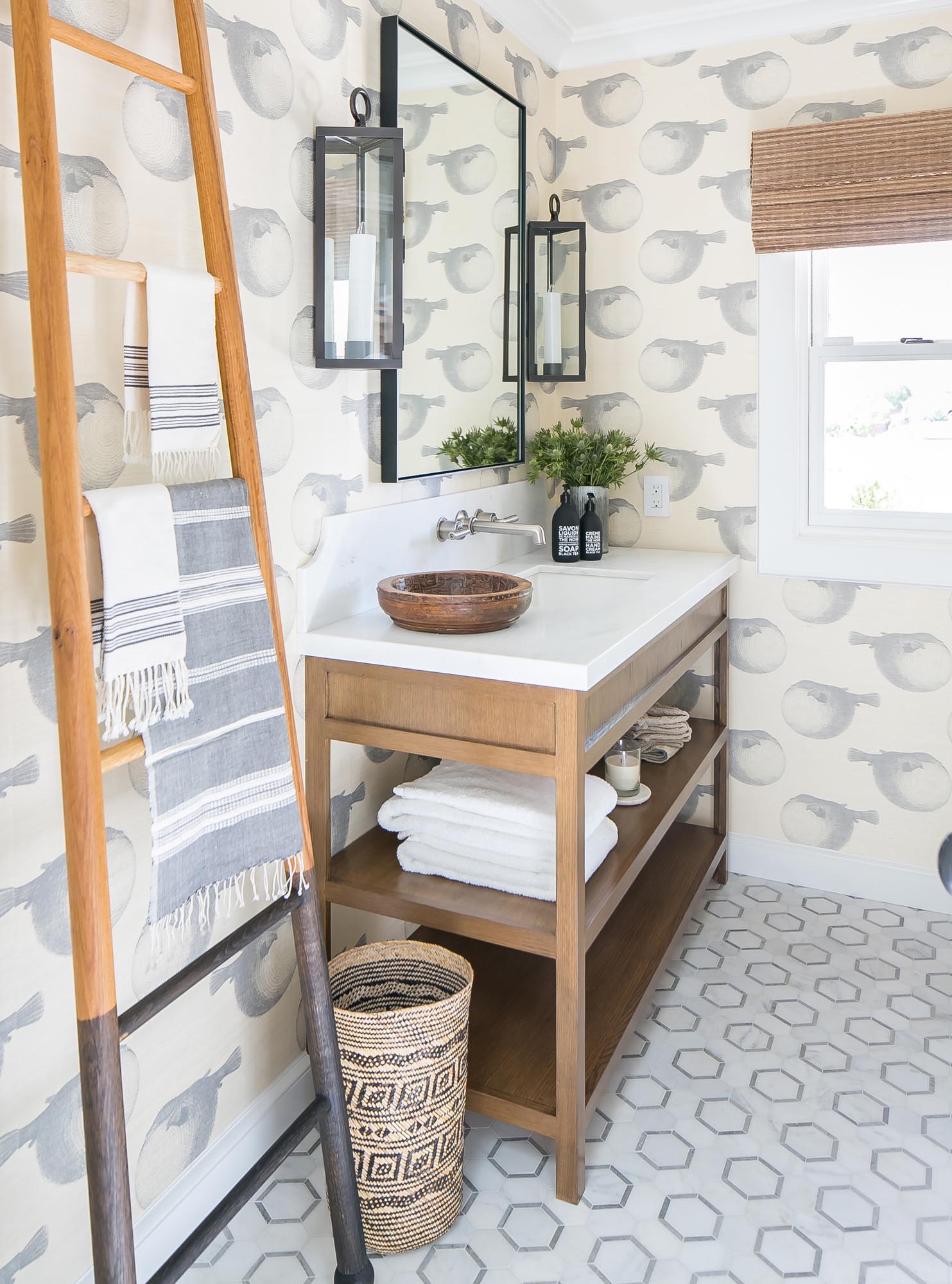 Photo of a bathroom with geometric tiles and a wallpaper featuring oversized birds.