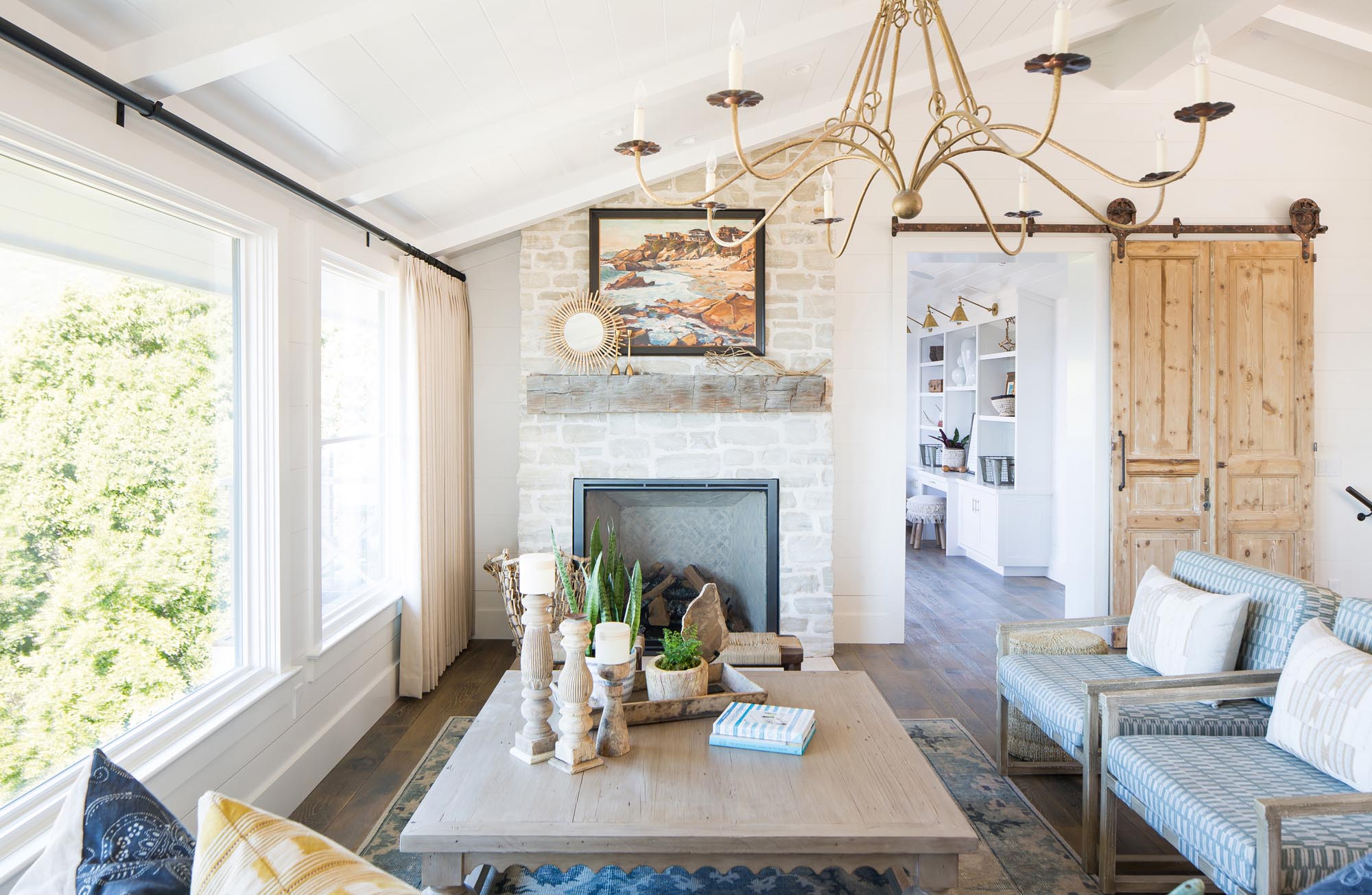 Photo of a hearth and coffee table with a delicate chandelier above.