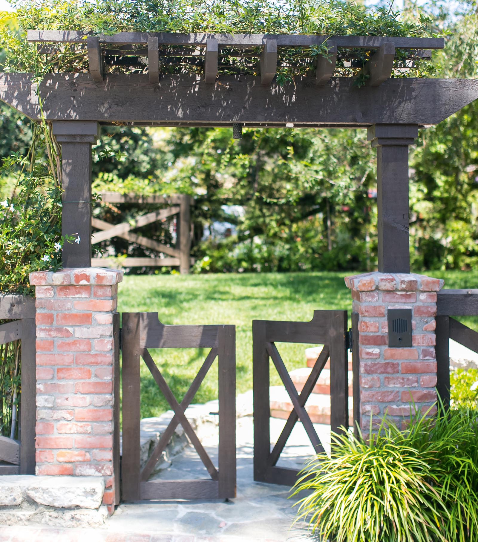 Photo of a gate with an arbor and greenery.