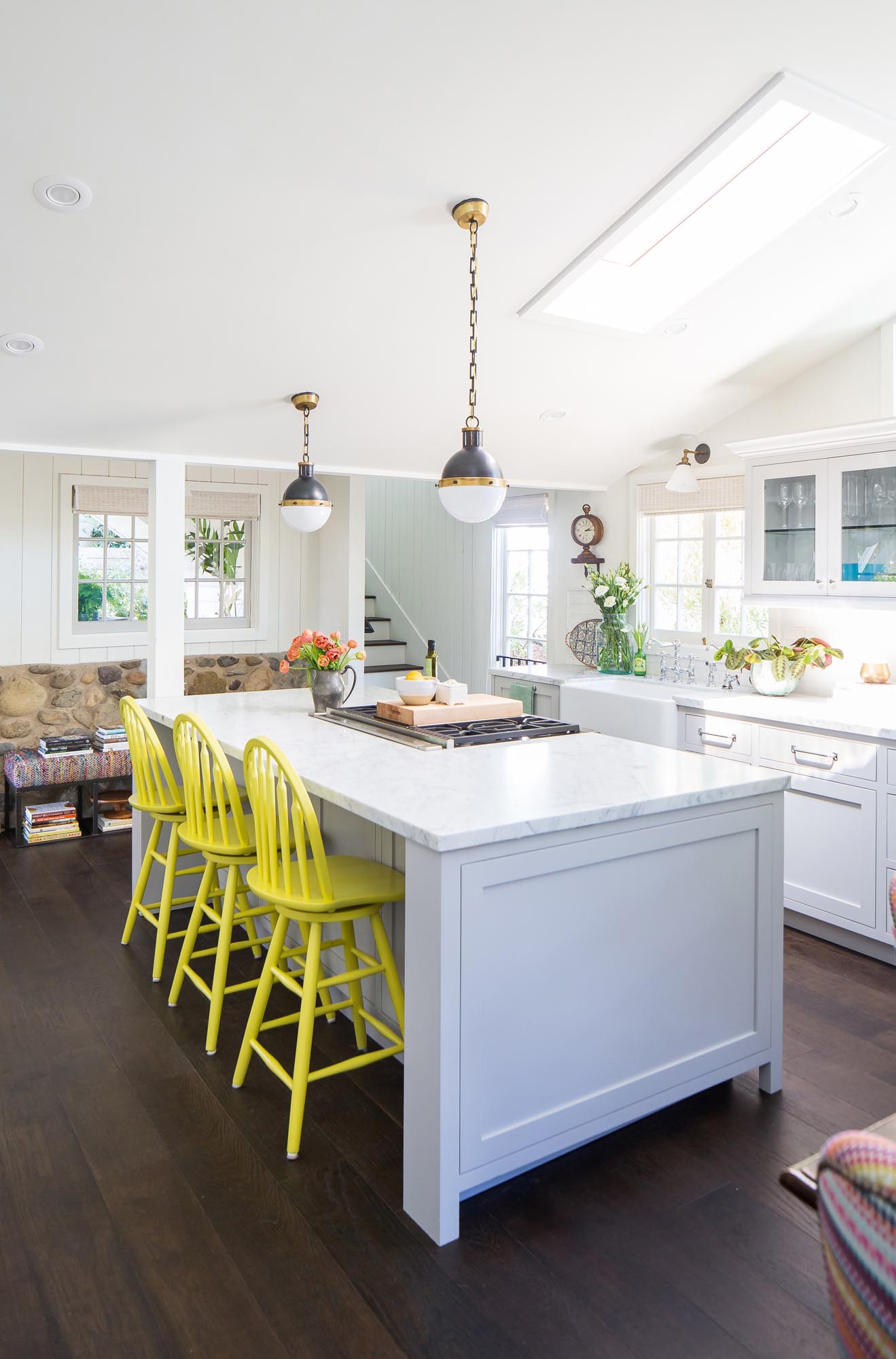 The yellow chairs tucked under the kitchen island is another indication of the owner’s love of color.