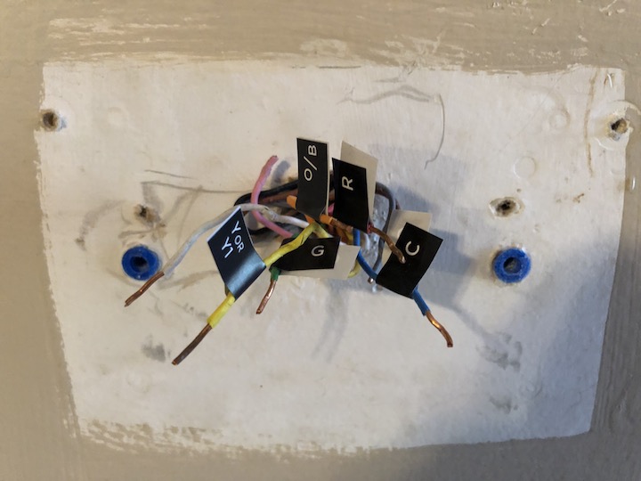 Figure 54: The ecobee thermostat without the trim plate wasn’t enough to cover this mess! Note the unused wires that I’m ignoring. You also probably want to remove any unused drywall anchors to ensure an even surface for the thermostat and plate to rest on.