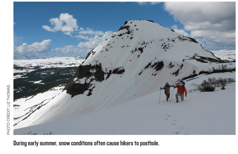 During early summer, snow conditions often cause hikers to posthole.