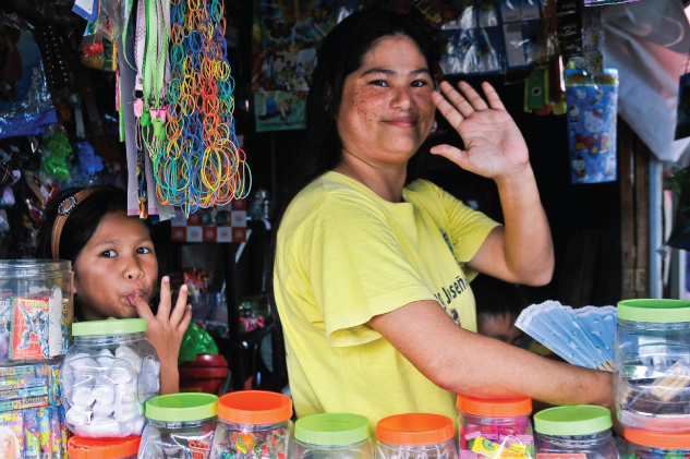 Photo showing a woman and a young girl running a kiosk.