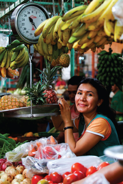 Photo showing a woman running a fruit stall.