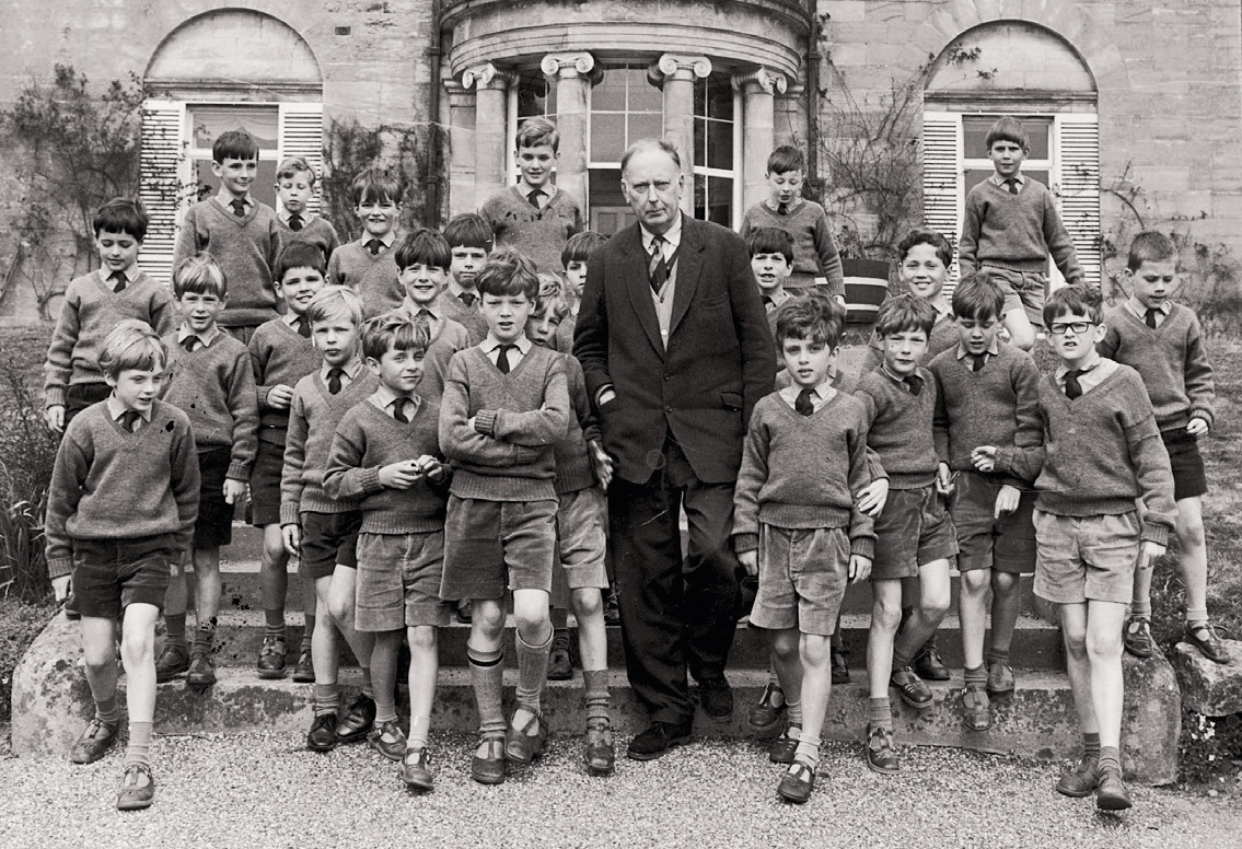 Billie Williamson, caustic classicist and Headmaster of Ashdown House prep school, with inmates.