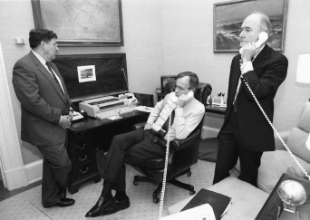 President Bush and Scowcroft on the phone with Secretary of State James Baker from the Oval Office Study; Governor John Sununu looks on (January 16, 1991). GEORGE BUSH PRESIDENTIAL LIBRARY AND MUSEUM