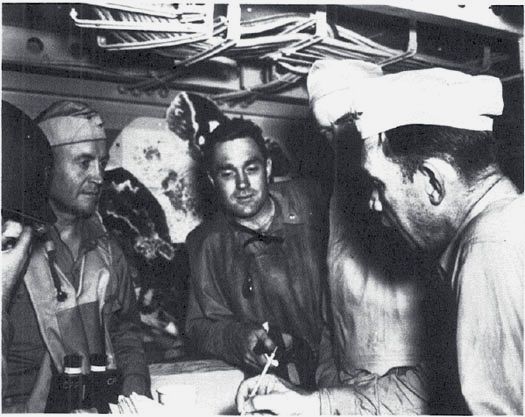 Lt. Cdr. Courtney Shands (center), VF-71 CO, with Capt. Forrest Sherman (l), Lt. Cdr. John Shea, and Cdr. Michael Kernodle (r), in the Wasp’s air plot, 7 Aug. 1942. (NA 80-G-12784)