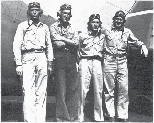 Mach. Don Runyon, Howard Packard, AP1c, Ens. Joe Shoemaker, and Ens. Will Rouse (l to r) of VF-6 stand in front of F-31 (BuNo. 5126), 10 Aug. 1942. (NA 80-G-11092)