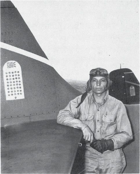 Mach. Don Runyon stands next to the tail of VF-6 F4F F-13 (BuNo. 5193) on the Enterprise, 9 Sept. 1942.